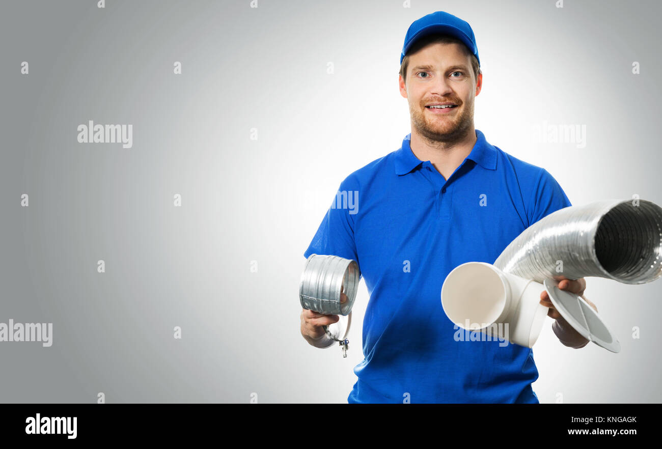 Lavoratore hvac con sistema di ventilazione apparecchiature in mani su sfondo grigio Foto Stock