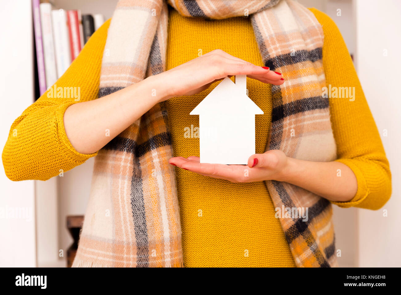 Donna in felpa gialla azienda di piccole dimensioni e di colore bianco  modello di casa dal suo cuore come segno di sogno di casa e protezione home  Foto stock - Alamy