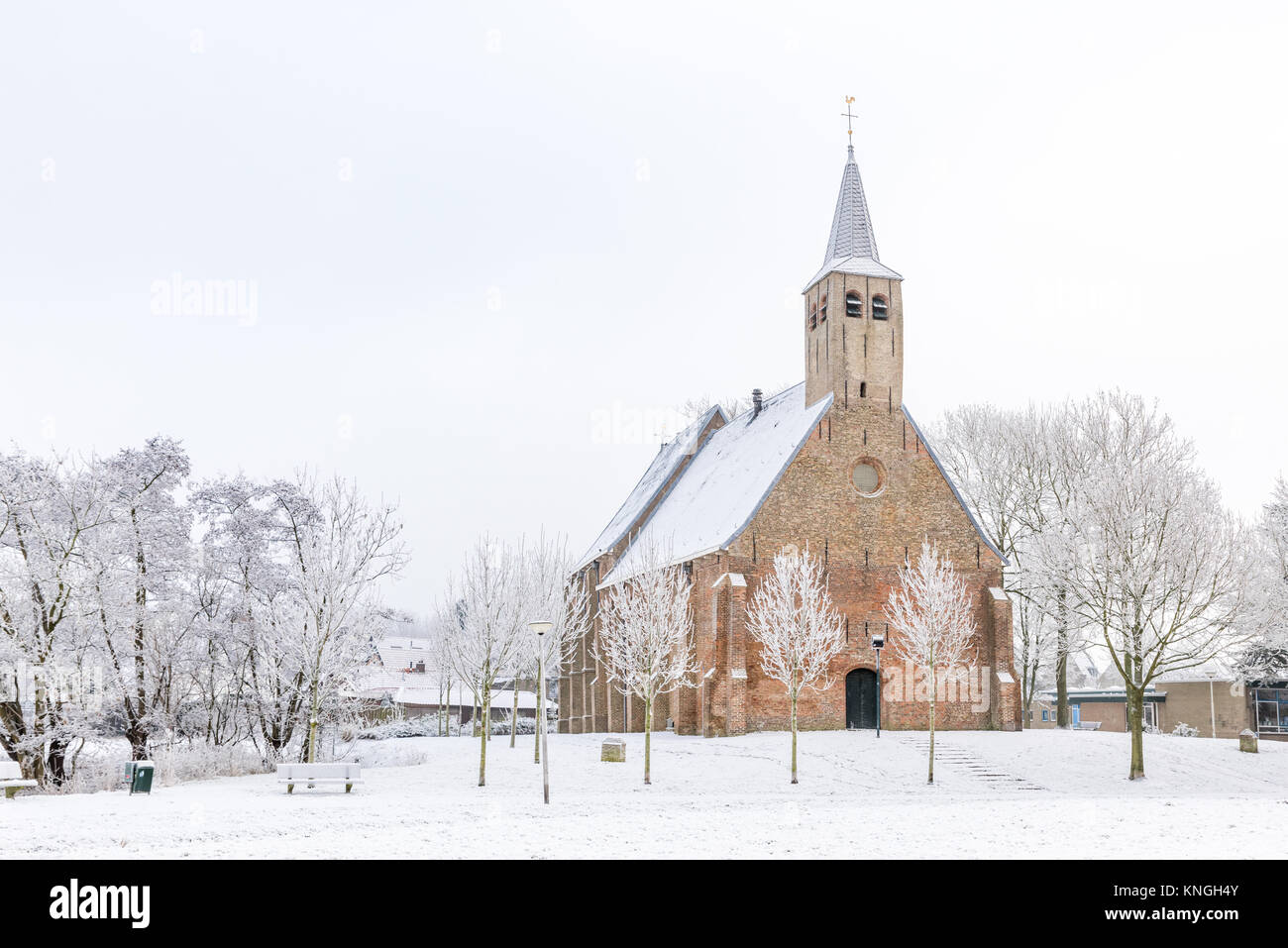 La storica chiesa Martinus in Zwartewaal nei Paesi Bassi durante il periodo invernale con neve e alberi hoarfrosted. Foto Stock