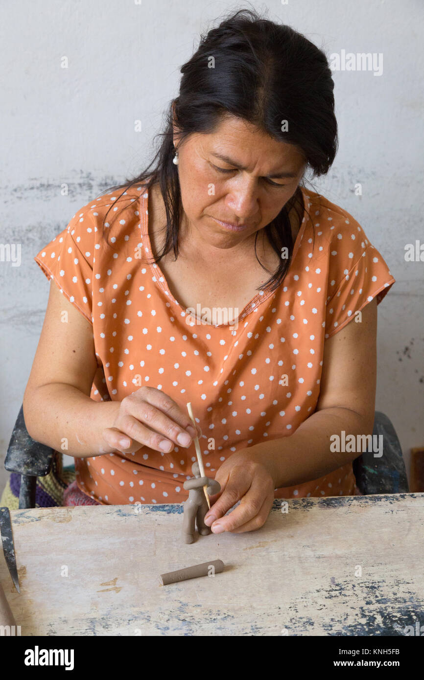 Ecuador mestieri - un craftswoman rendendo creta cifre quindi il fuoco e la vernice, Cuenca, Ecuador America del Sud Foto Stock