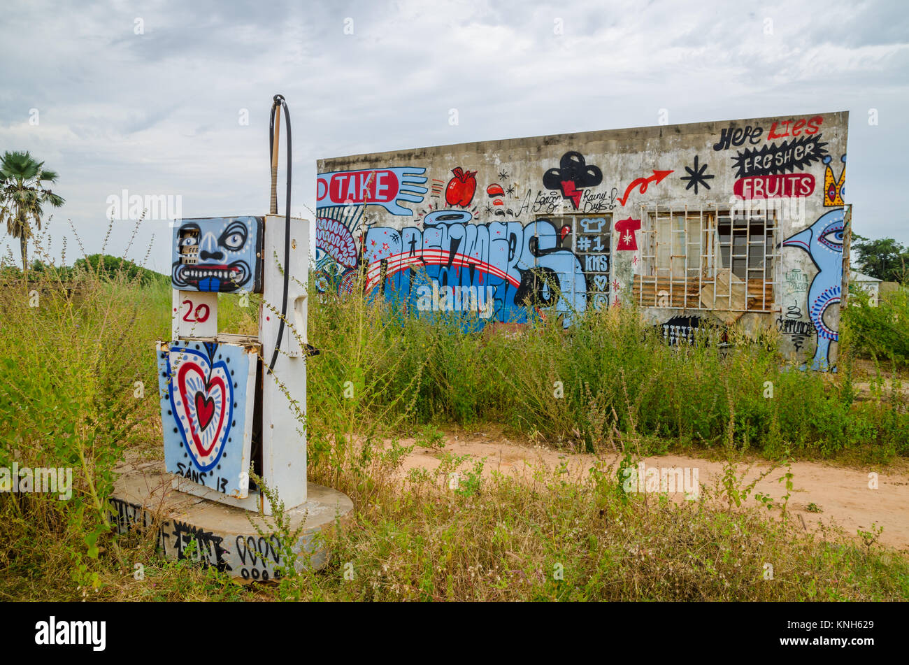 Abbandonato ed incolto gas station con colorati graffiti e drammatico sky Foto Stock