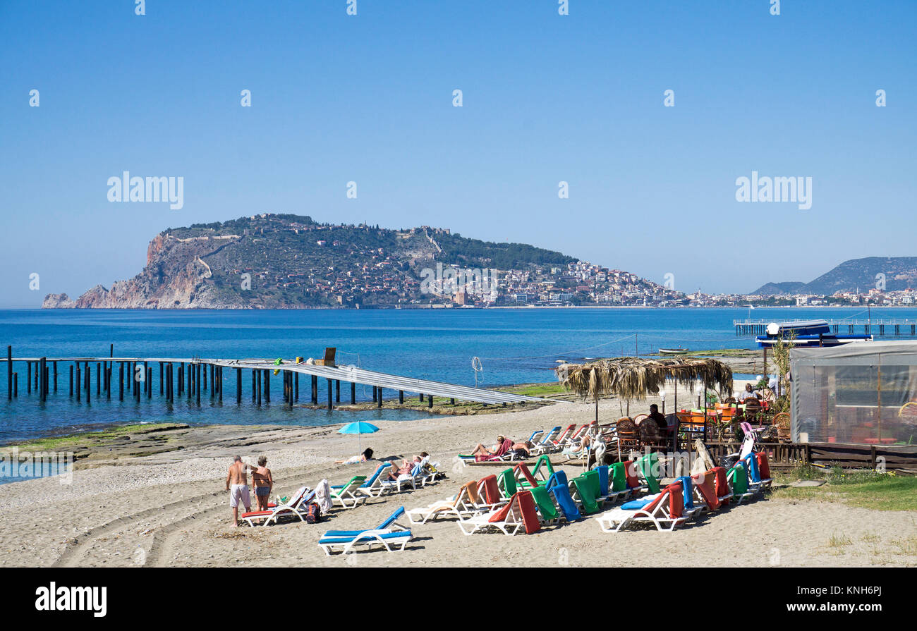 Il bar sulla spiaggia con sunbedsat alla spiaggia Oba, dietro la collina del castello, Alanya, riviera turca, Turchia Foto Stock