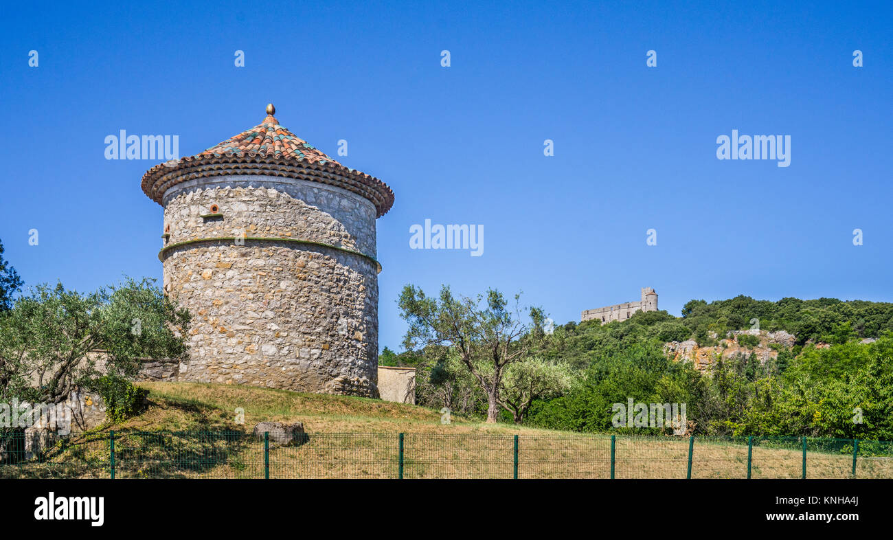 Francia, regione Occitanie, Gard reparto, Occitano Round Tower presso La Madeleine contro lo sfondo di Chateau de Tornac Foto Stock