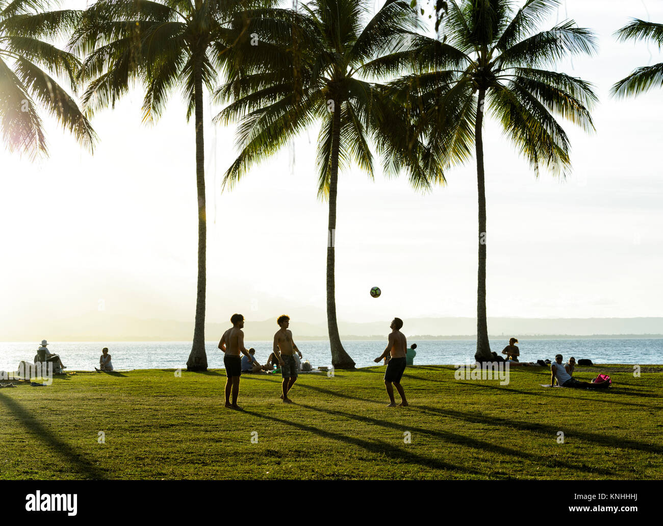 I giovani uomini a giocare a calcio al Rex Smeal Park al tramonto, Port Douglas, estremo Nord Queensland, FNQ, QLD, Australia Foto Stock