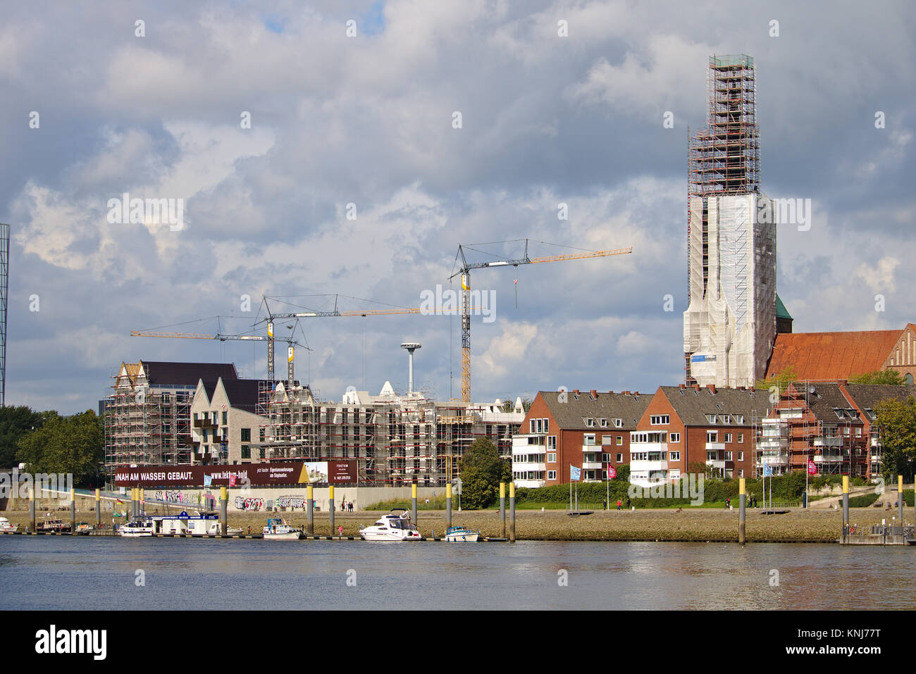 Bremen, Germania - Settembre 14th, 2017 - Riverside sito in costruzione di gru, ponteggi parzialmente e completamente completata edifici residenziali, chiesa Foto Stock