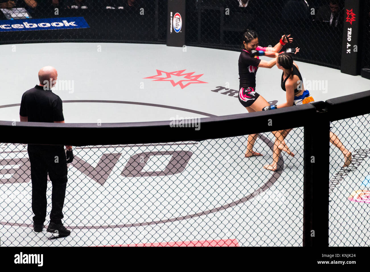 Bangkok, Tailandia. - 9 Dicembre 2017 : Roma Trinidad (Philippine) la punzonatura sulla faccia Rika Ishige (Thailandia) a combattere in gabbia ring sport estremo di mixed martial arts (MMA) corrispondono ad un Campionato torneo di concorrenza Foto Stock