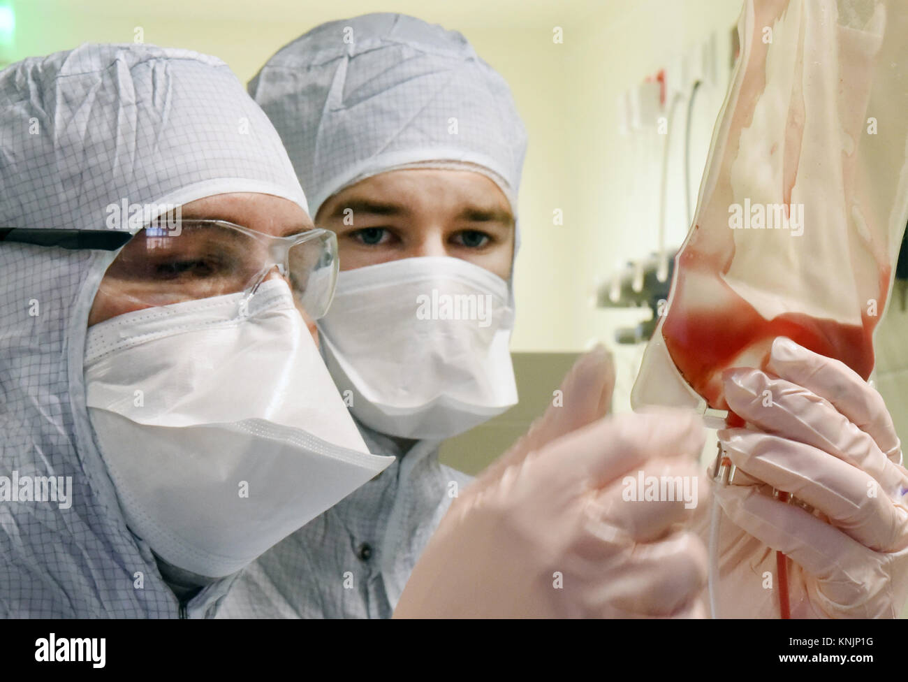 La tecnica farmaceutica assistente Michael Nemetz e il laboratorio biologico tecnico Simon Kuebler (R) il lavoro su una nuova forma di cella personalizzato terapia contro il cancro con alta tecnologia specializzata all'interno di una camera pulita presso l'Istituto Fraunhofer per la terapia cellulare e l'Immunologia (IZI) a Leipzig, Germania, 20 novembre 2017. Il Fraunhofer Institute sta lavorando sul progetto congiunto con la società Novartis Pharma AG al fine di sviluppare adeguatamente la nuova forma di terapia, l'antigene chimerico terapia del recettore (carrello). Esso richiede la riprogrammazione dei pazienti· proprie cellule immunitarie di trattare i loro Foto Stock