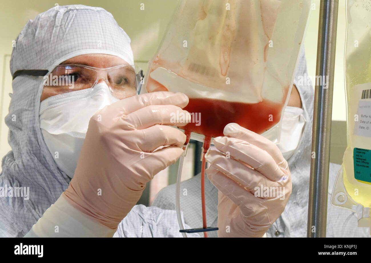 La tecnica farmaceutica assistente Michael Nemetz lavora su una nuova forma di cella personalizzato terapia contro il cancro con alta tecnologia specializzata all'interno di una camera pulita presso l'Istituto Fraunhofer per la terapia cellulare e l'Immunologia (IZI) a Leipzig, Germania, 20 novembre 2017. Il Fraunhofer Institute sta lavorando sul progetto congiunto con la società Novartis Pharma AG al fine di sviluppare adeguatamente la nuova forma di terapia, l'antigene chimerico terapia del recettore (carrello). Esso richiede la riprogrammazione dei pazienti· proprie cellule immunitarie di trattare il loro tumore. Le cellule del cancro saranno quindi riconosciute e distrutti Foto Stock
