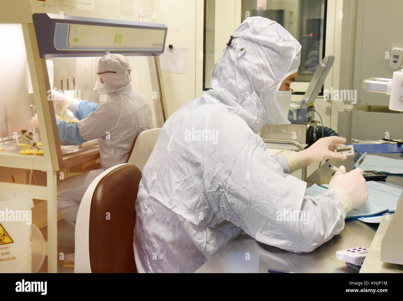 La tecnica farmaceutica assistente Michael Nemetz e il laboratorio biologico tecnico Simon Kuebler (R) il lavoro su una nuova forma di cella personalizzato terapia contro il cancro con alta tecnologia specializzata all'interno di una camera pulita presso l'Istituto Fraunhofer per la terapia cellulare e l'Immunologia (IZI) a Leipzig, Germania, 20 novembre 2017. Il Fraunhofer Institute sta lavorando sul progetto congiunto con la società Novartis Pharma AG al fine di sviluppare adeguatamente la nuova forma di terapia, l'antigene chimerico terapia del recettore (carrello). Esso richiede la riprogrammazione dei pazienti· proprie cellule immunitarie di trattare i loro Foto Stock