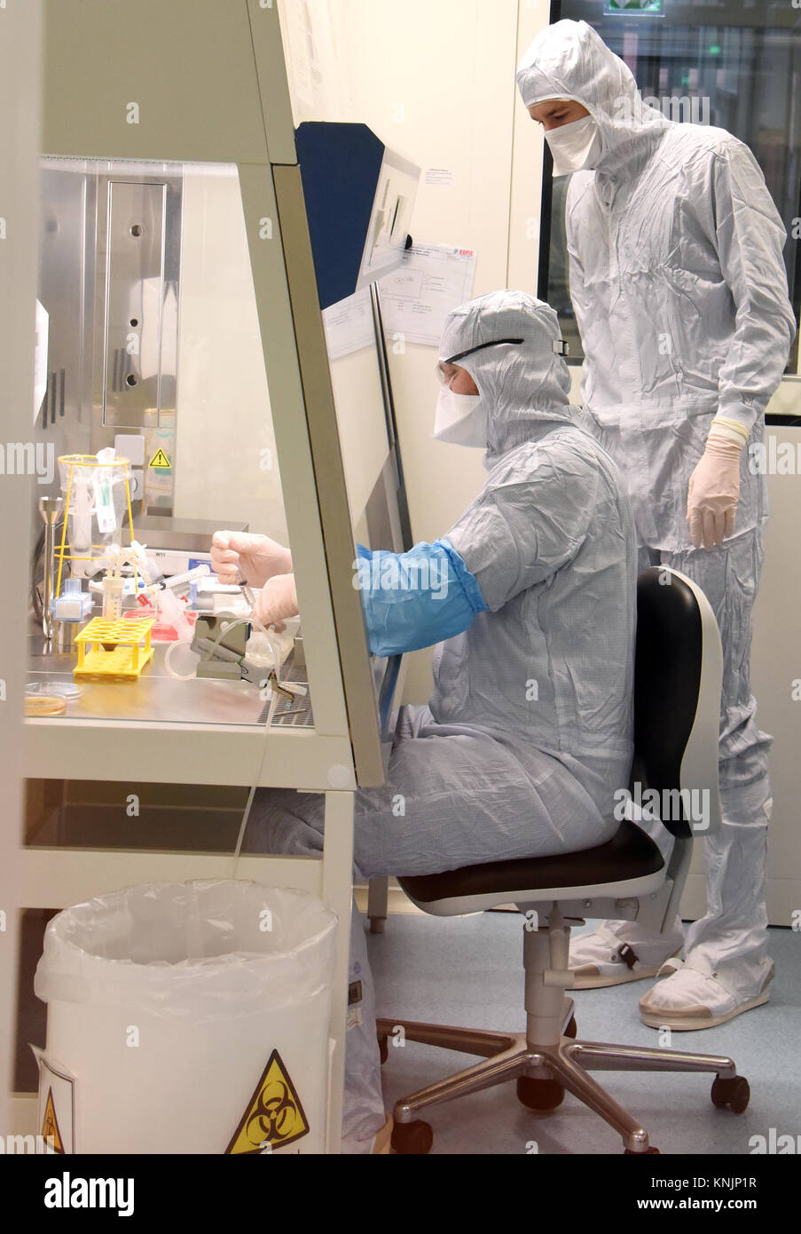 La tecnica farmaceutica assistente Michael Nemetz e il laboratorio biologico tecnico Simon Kuebler (R) il lavoro su una nuova forma di cella personalizzato terapia contro il cancro con alta tecnologia specializzata all'interno di una camera pulita presso l'Istituto Fraunhofer per la terapia cellulare e l'Immunologia (IZI) a Leipzig, Germania, 20 novembre 2017. Il Fraunhofer Institute sta lavorando sul progetto congiunto con la società Novartis Pharma AG al fine di sviluppare adeguatamente la nuova forma di terapia, l'antigene chimerico terapia del recettore (carrello). Esso richiede la riprogrammazione dei pazienti· proprie cellule immunitarie di trattare i loro Foto Stock
