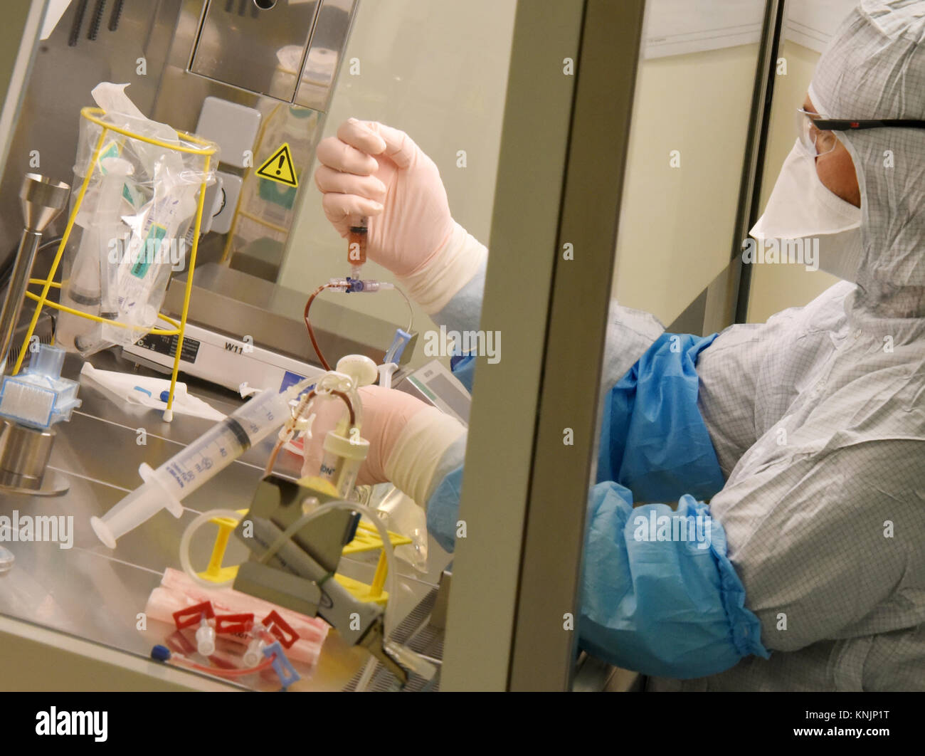 La tecnica farmaceutica assistente Michael Nemetz lavora su una nuova forma di cella personalizzato terapia contro il cancro con alta tecnologia specializzata all'interno di una camera pulita presso l'Istituto Fraunhofer per la terapia cellulare e l'Immunologia (IZI) a Leipzig, Germania, 20 novembre 2017. Il Fraunhofer Institute sta lavorando sul progetto congiunto con la società Novartis Pharma AG al fine di sviluppare adeguatamente la nuova forma di terapia, l'antigene chimerico terapia del recettore (carrello). Esso richiede la riprogrammazione dei pazienti· proprie cellule immunitarie di trattare il loro tumore. Le cellule del cancro saranno quindi riconosciute e distrutti Foto Stock