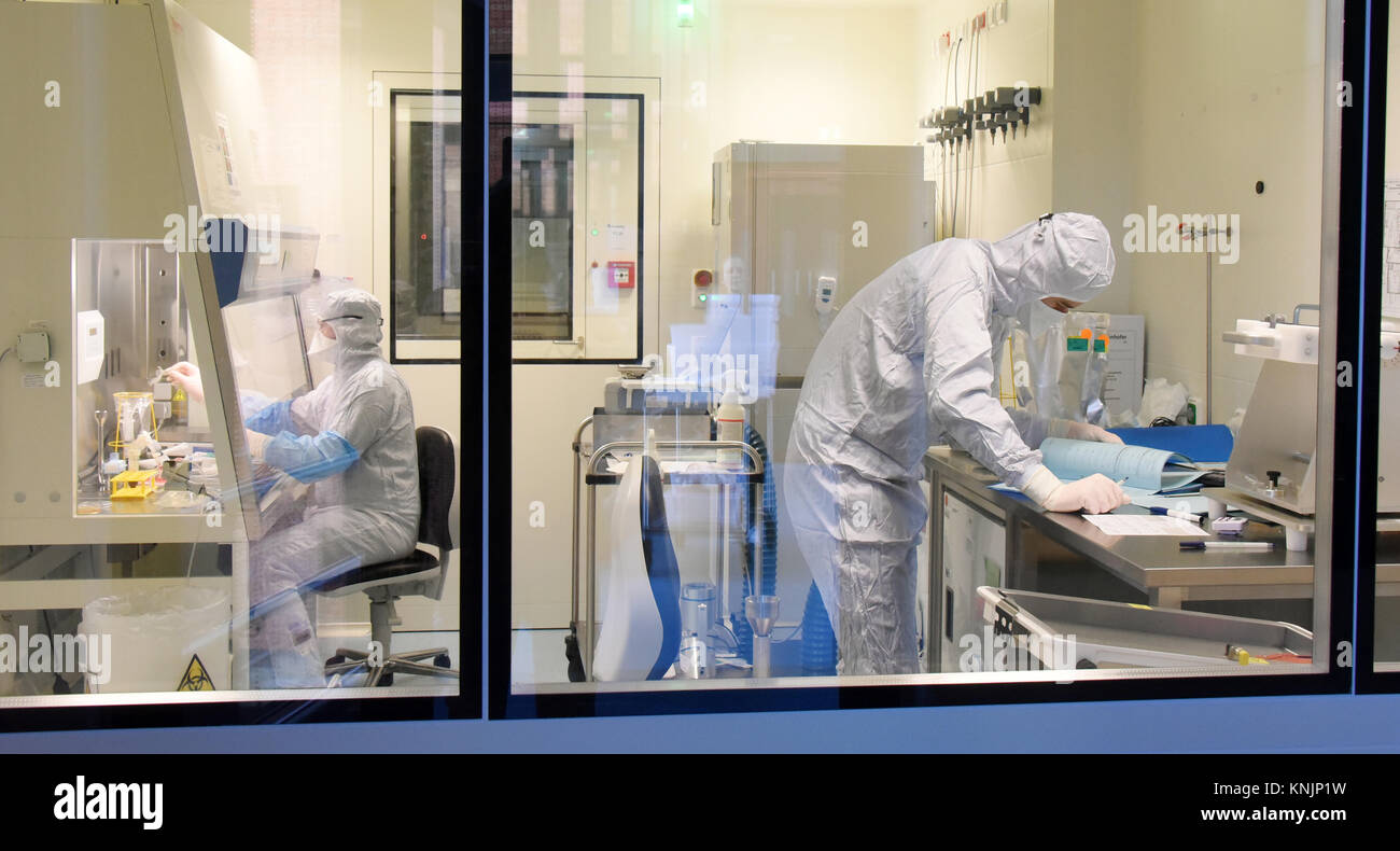 La tecnica farmaceutica assistente Michael Nemetz e il laboratorio biologico tecnico Simon Kuebler (R) il lavoro su una nuova forma di cella personalizzato terapia contro il cancro con alta tecnologia specializzata all'interno di una camera pulita presso l'Istituto Fraunhofer per la terapia cellulare e l'Immunologia (IZI) a Leipzig, Germania, 20 novembre 2017. Il Fraunhofer Institute sta lavorando sul progetto congiunto con la società Novartis Pharma AG al fine di sviluppare adeguatamente la nuova forma di terapia, l'antigene chimerico terapia del recettore (carrello). Esso richiede la riprogrammazione dei pazienti· proprie cellule immunitarie di trattare i loro Foto Stock