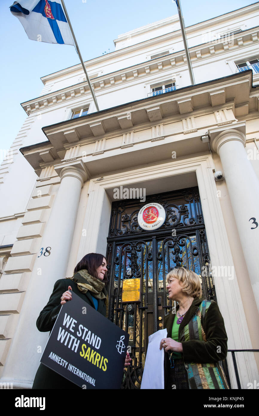 Londra, Regno Unito. Dodicesimo Dicembre, 2017. Un rappresentante di Amnesty International mani una petizione al Marjo Mäki-Leppilampi, Consigliere per gli affari politici presso l' ambasciata di Finlandia durante una manifestazione di protesta per chiedere la revisione della Finlandia " pre-storica" trans leggi di sterilizzazione e nella solidarietà con Sakris Kupila, un 21-anno-vecchio finlandese attivista per i diritti umani per difendere i diritti transgender e campagne di sensibilizzazione per cambiare il suo paese le leggi. Credito: Mark Kerrison/Alamy Live News Foto Stock