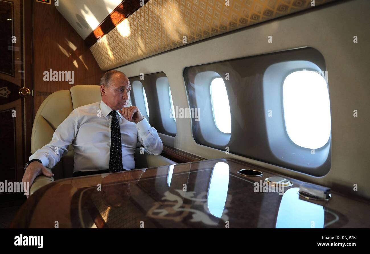 Il presidente russo Vladimir Putin guarda fuori dalla finestra del suo aereo a sua scorta di russo Sukhoi Su-30 aerei da combattimento come egli entra nello spazio aereo siriano sul suo modo di visitare truppe a Khmeimim Air Base Dicembre 11, 2017 in Laodicea, Siria. Putin ha annunciato il ritiro della maggior parte delle forze russe dalla Siria in seguito alla guerra contro lo Stato islamico. Foto Stock