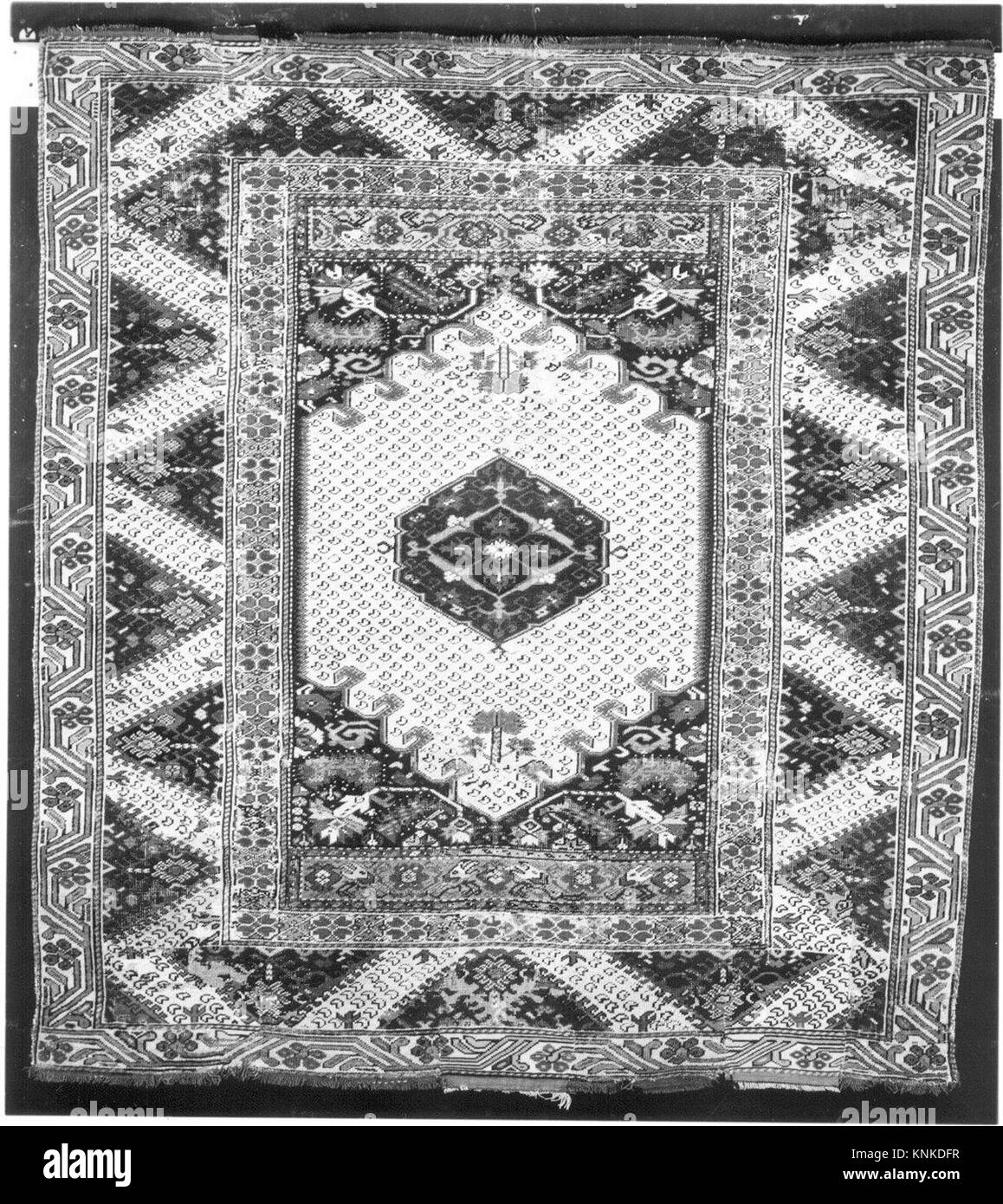 Tappeto turco del XIX secolo in lana con ordito, trama e pelo. Presenta un pelo intrecciato simmetricamente e motivi decorativi caratteristici delle tradizioni di tessitura ottomana. Foto Stock