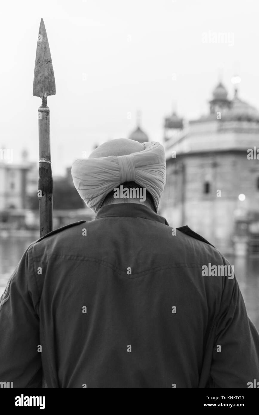 AMRITSAR, India - 20 Marzo 2016: verticale immagine in bianco e nero di custode indiano con lancia a Sri Harmandir Sahib, noto come tempio d'Oro, sito Foto Stock