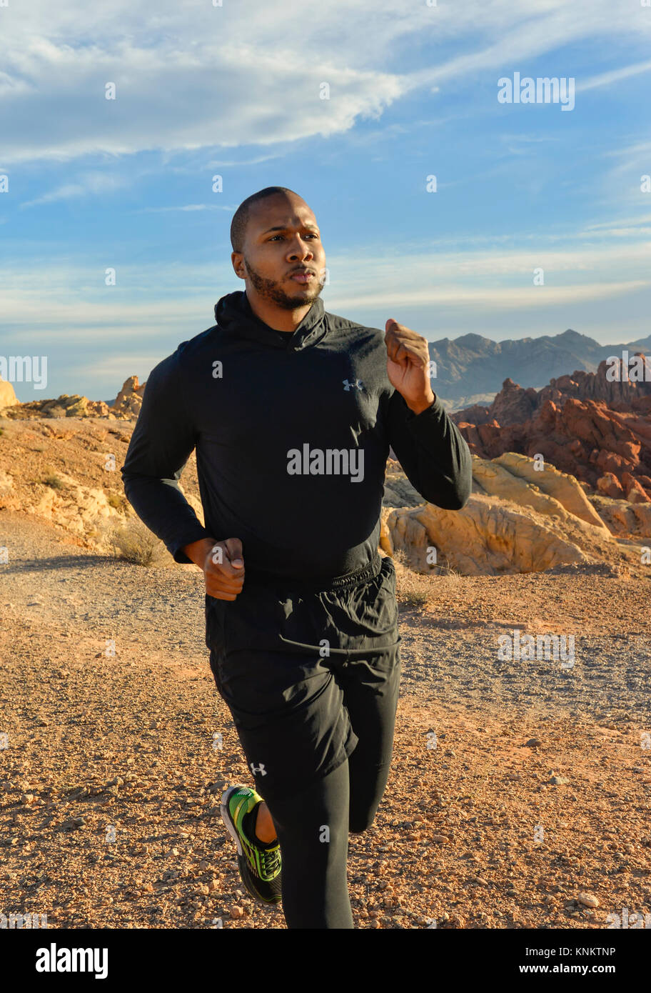 African American uomo formazione per 10k correre nel deserto del Nevada. Foto Stock