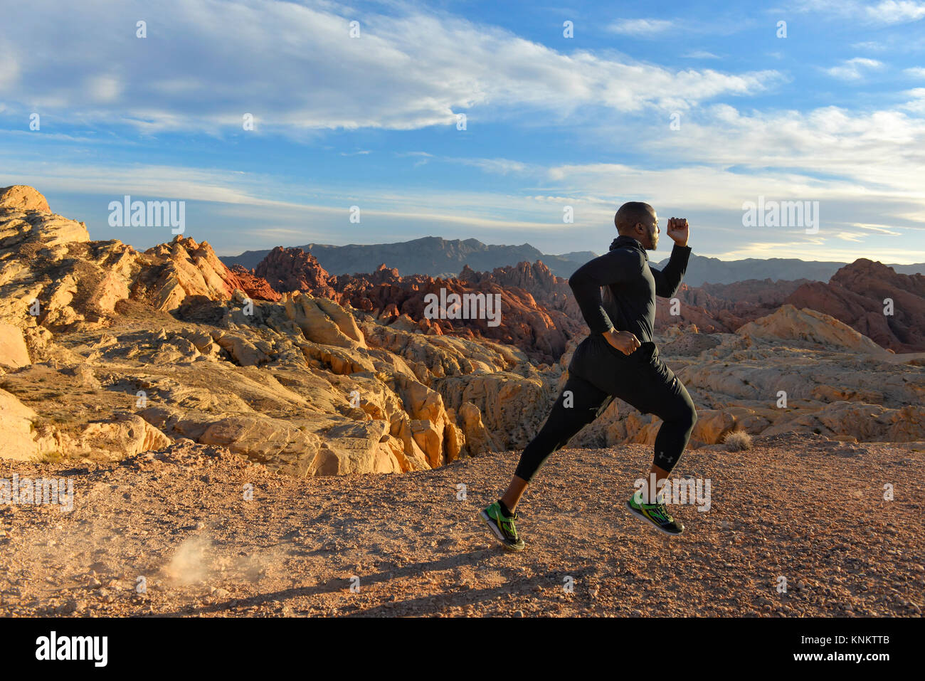 African American uomo formazione per 10k correre nel deserto del Nevada. Foto Stock
