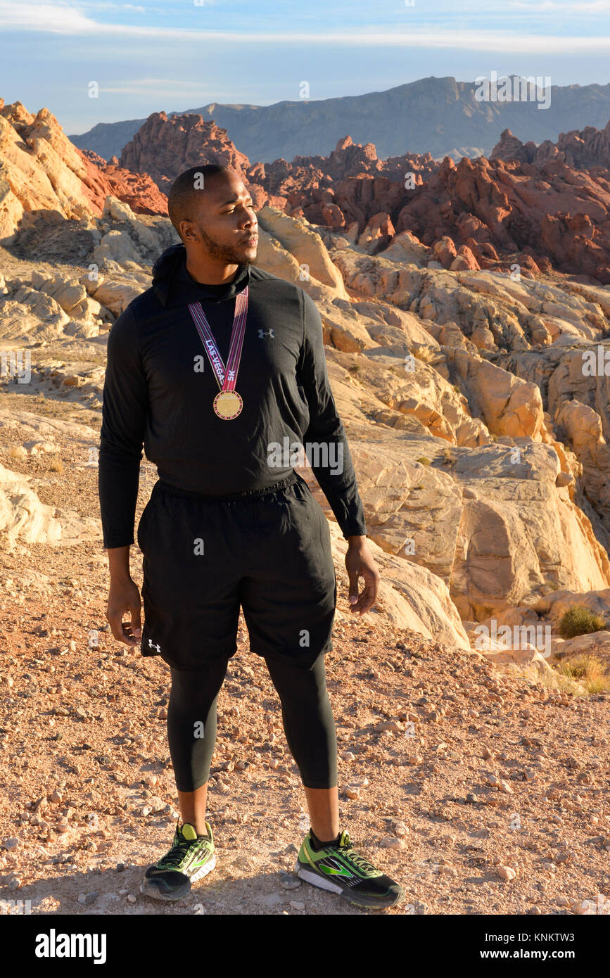 African American uomo formazione per 10k correre nel deserto del Nevada. Foto Stock