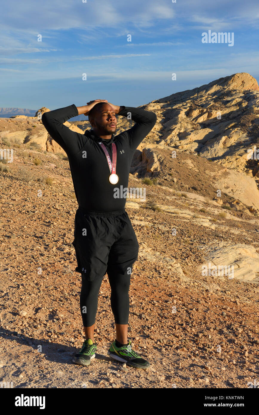 African American uomo formazione per 10k correre nel deserto del Nevada. Foto Stock