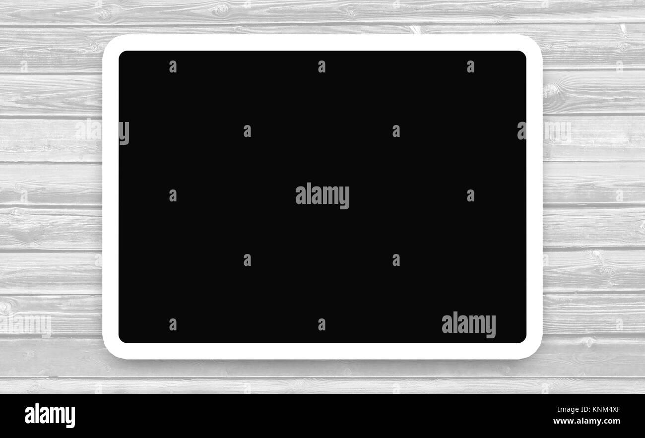 Tablet con schermo scuro su sfondo di legno. Cornice bianca con sfondo nero su tavola di legno con spazio per la copia del testo. Foto Stock