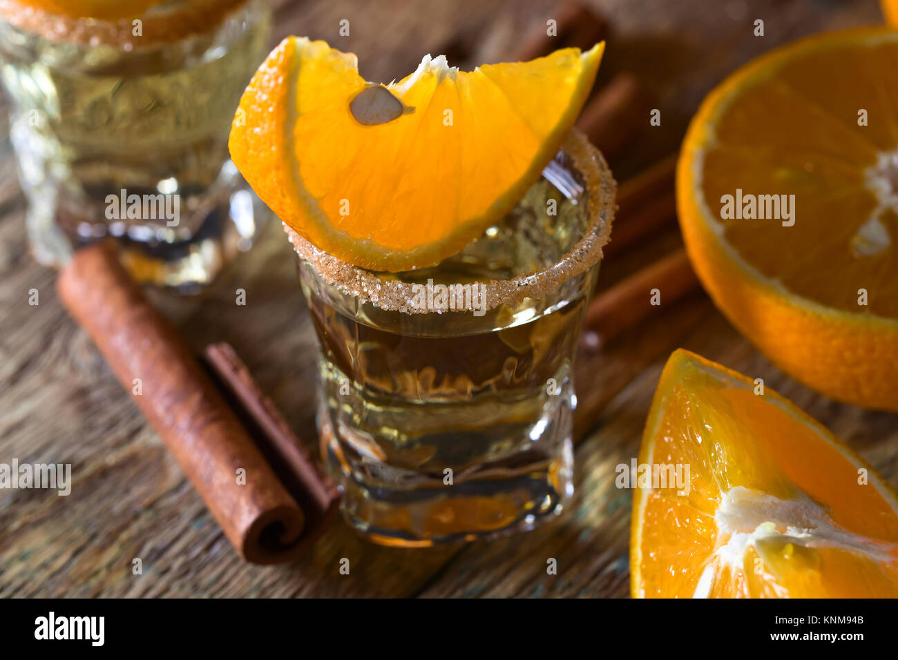 Bicchieri di tequila oro con arancia e cannella . Foto Stock