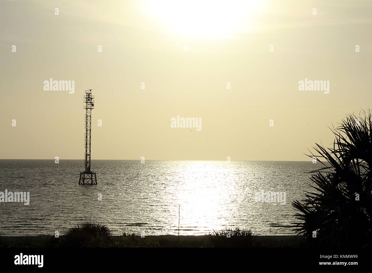 Florida, Golfo del Messico. Torre cellulare nell'acqua sul tramonto. Foto Stock