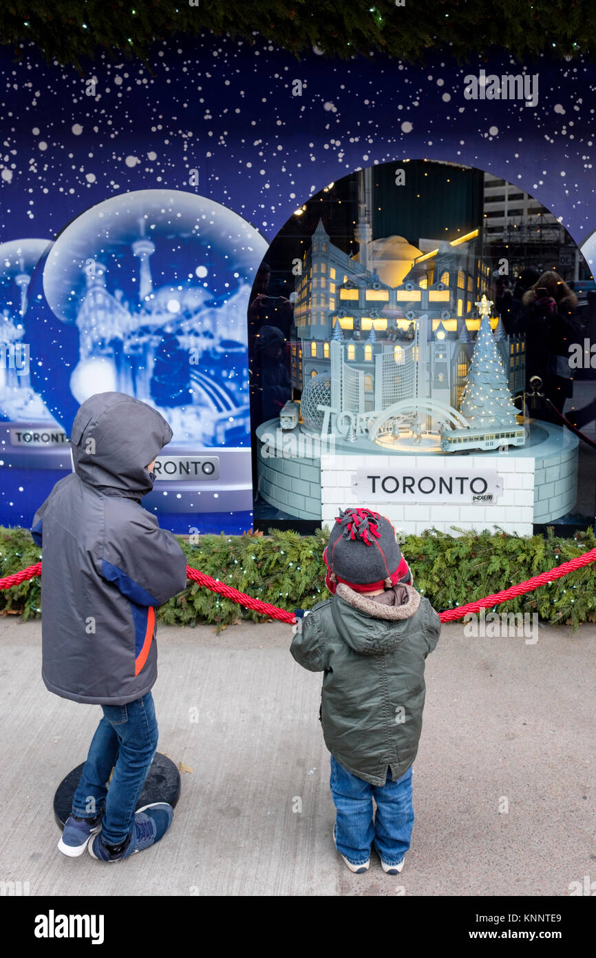 Gente della scena natalizia, bambini che guardano la finestra delle vacanze natalizie di Saks Fifth Avenue nel centro di Toronto, Canada. Foto Stock