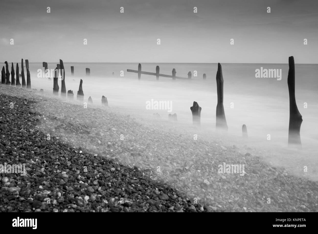 Bianco e nero creepy lunga esposizione, prese a lungo la costa di Winchelsea Beach. Foto Stock