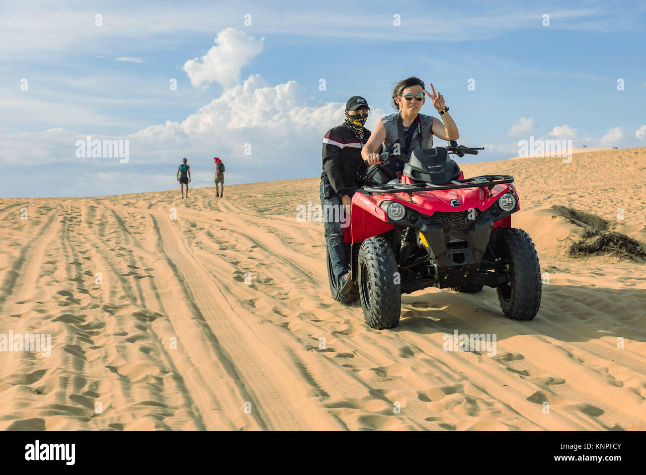 MUI NE, VIETNAM - MARZO 24, 2017. Un giovane uomo con un cappuccio sulla sua testa corre off road sulle dune di sabbia. Off road automobile veicolo in bianco dune di sabbia del deserto alla m. Foto Stock