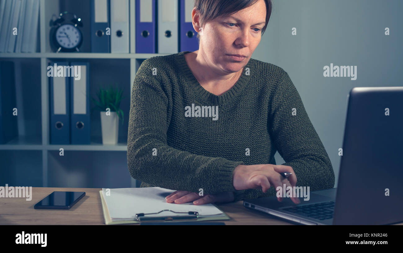 Femmina gravi freelancer lavorando sul computer portatile in ufficio a casa del suo piccolo business start up company Foto Stock