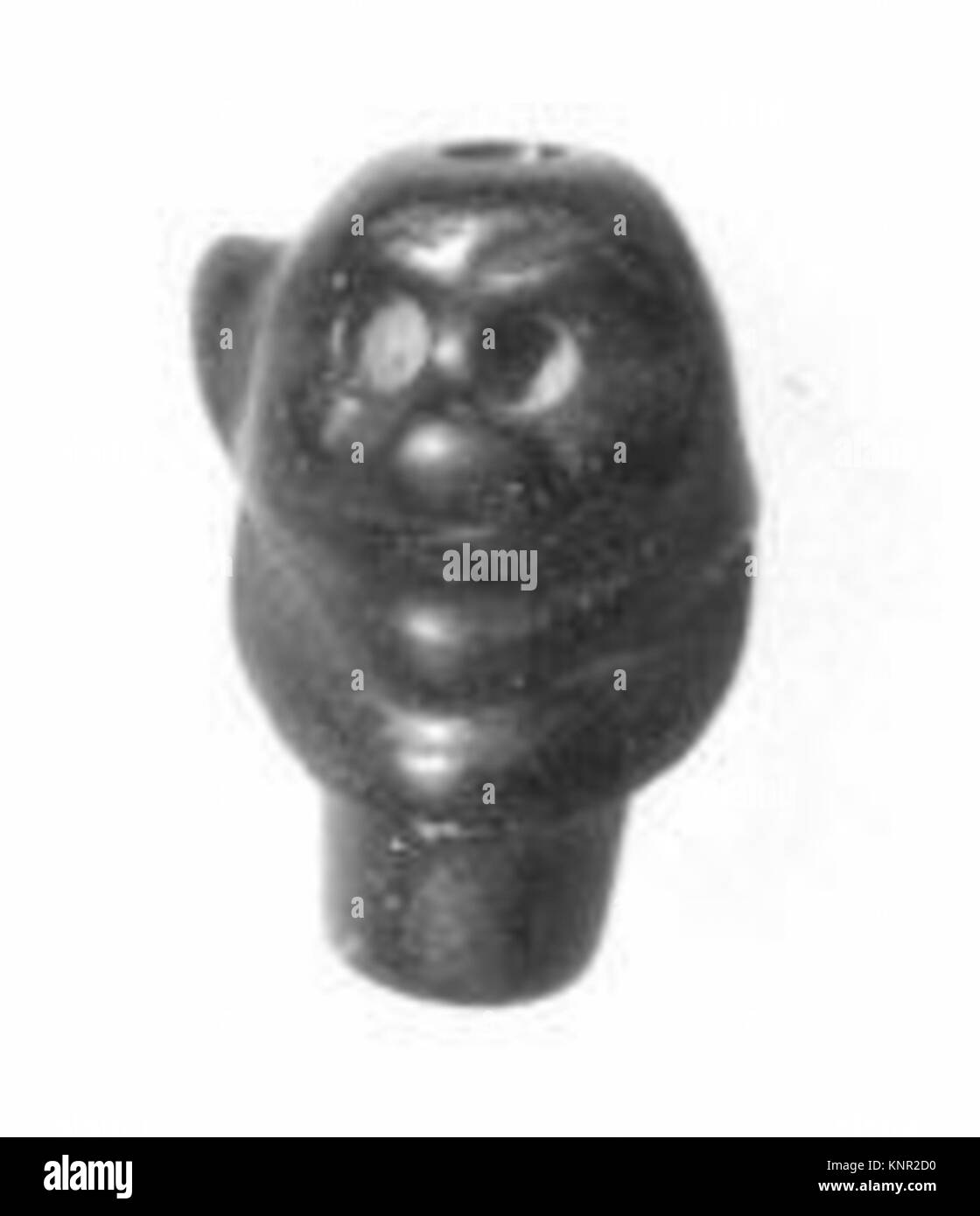 Perla a forma di testa di Pazuzu, fatta di argilla o pietra, che rappresenta figura mitologica in antichi rituali o uso decorativo. Foto Stock