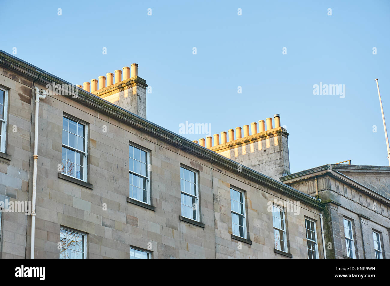 Righe di camini sul tetto di un tradizionale arenaria tenement house in Glasgow, UK. Foto Stock