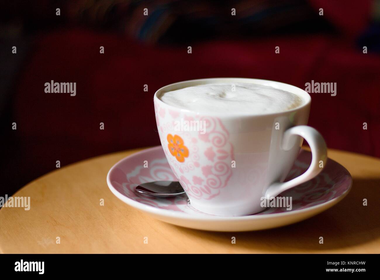 Tazza di caffè con schiuma di latte nella tazza decorata sul tavolo di legno sul luminoso Domenica mattina Foto Stock