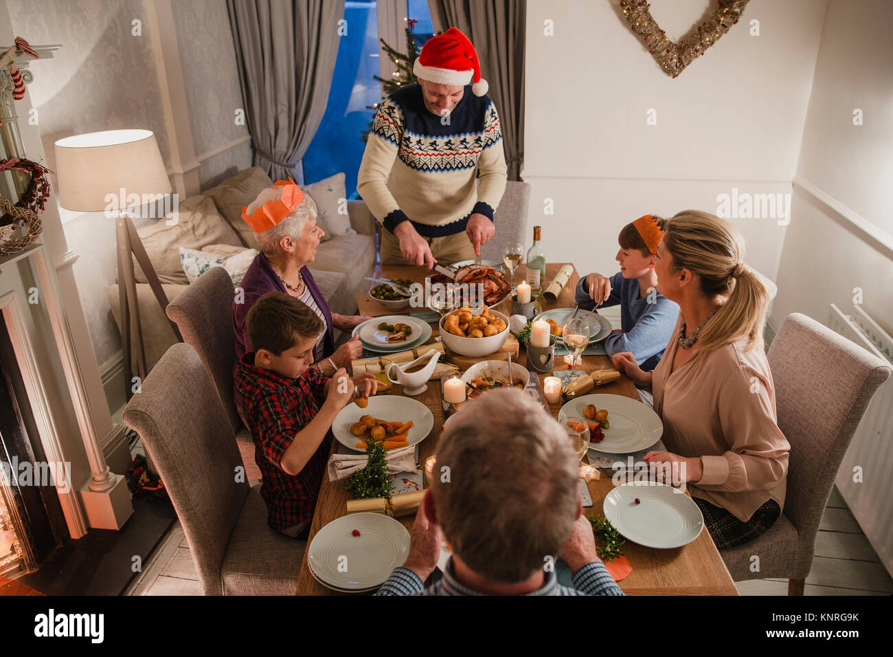 Tre generazioni la famiglia sono avente la cena di Natale. Il padre è il taglio della Turchia. Foto Stock