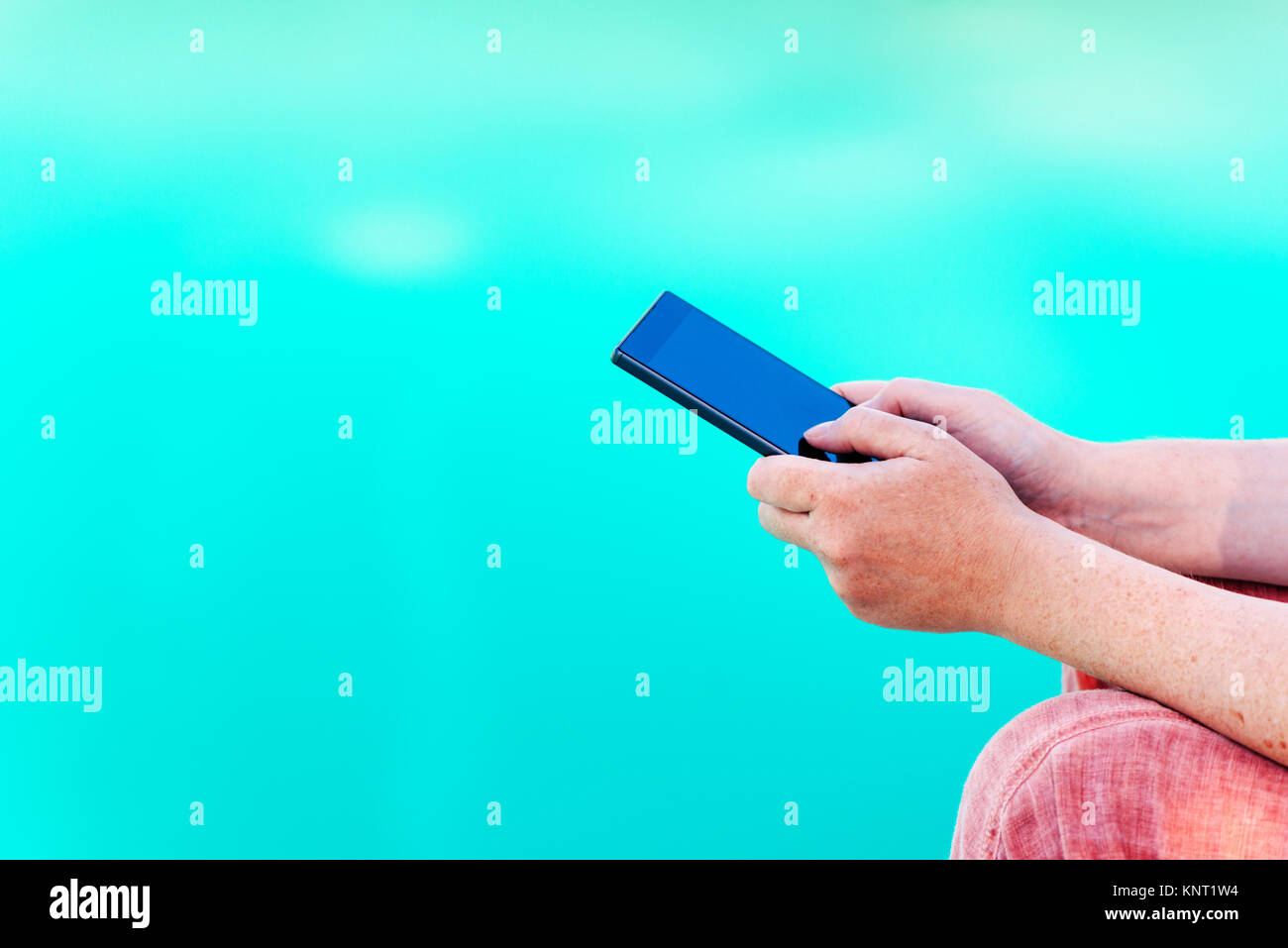 La donna gli sms sul cellulare dalla piscina, vacanze estive communication Foto Stock