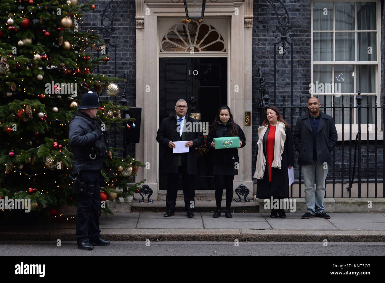 Vittime o familiari delle vittime del Grenfell Torre fire, Nicholas Burton (sinistra), Sandra Ruiz (seconda a destra), Karim Mussilhy (destra) e una ragazza che ha chiesto di non essere denominato (seconda a sinistra), la mano in una petizione a Downing Street, Londra, per chiedere una revisione dell'inchiesta pubblica. Foto Stock