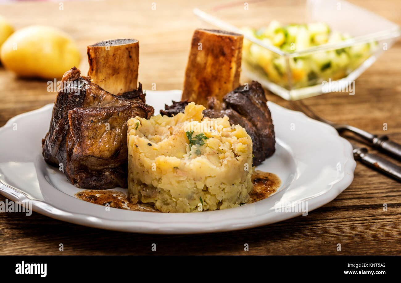 Grigliate di carni bovine nervatura con purè di patate sul tavolo di legno Foto Stock