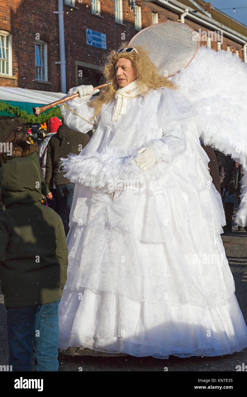 Angeli sfilano per le vie intrattenere i visitatori al Victorian festa di Natale, Portsmouth Historic Dockyard, Portsmouth, Hants Regno Unito nel mese di dicembre Foto Stock