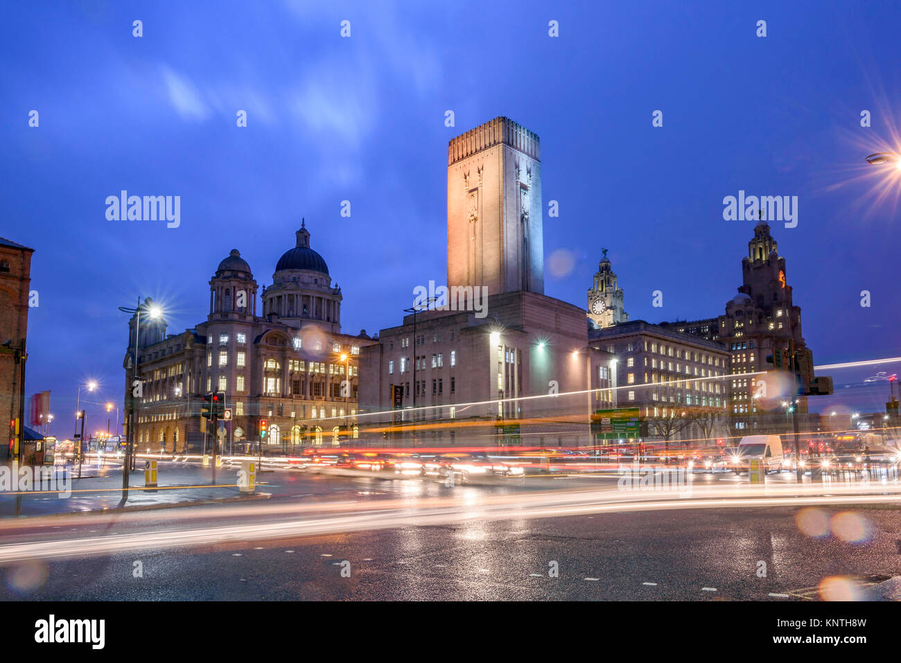 Liverpool edifici pierhead visto dal filamento durante la notte con il traffico impetuoso passato. Foto Stock