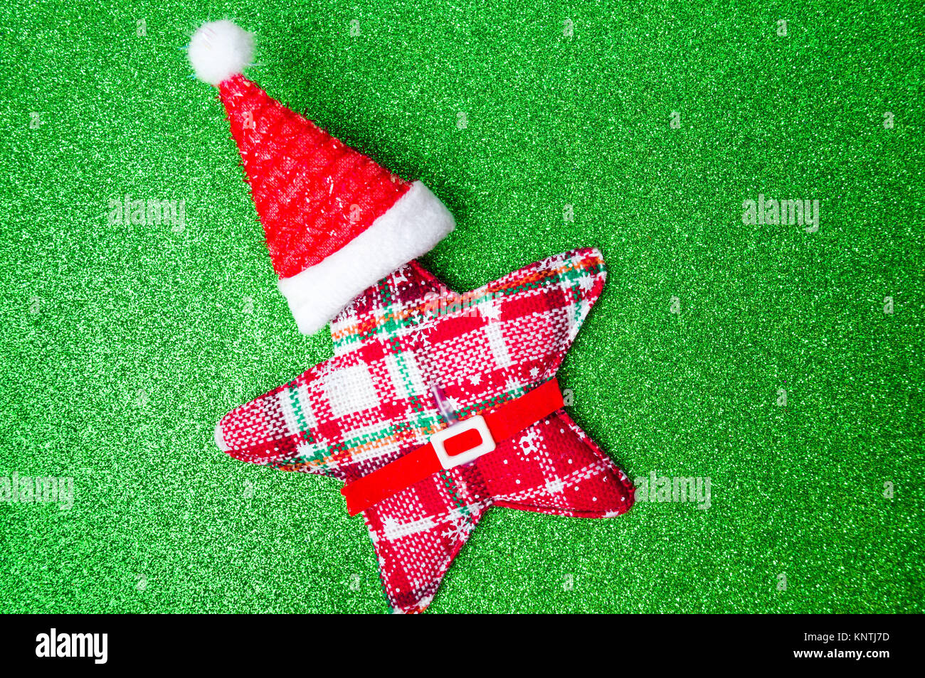 Giocattolo di Natale stella con Santa hat sul verde sfondo glitter Foto Stock