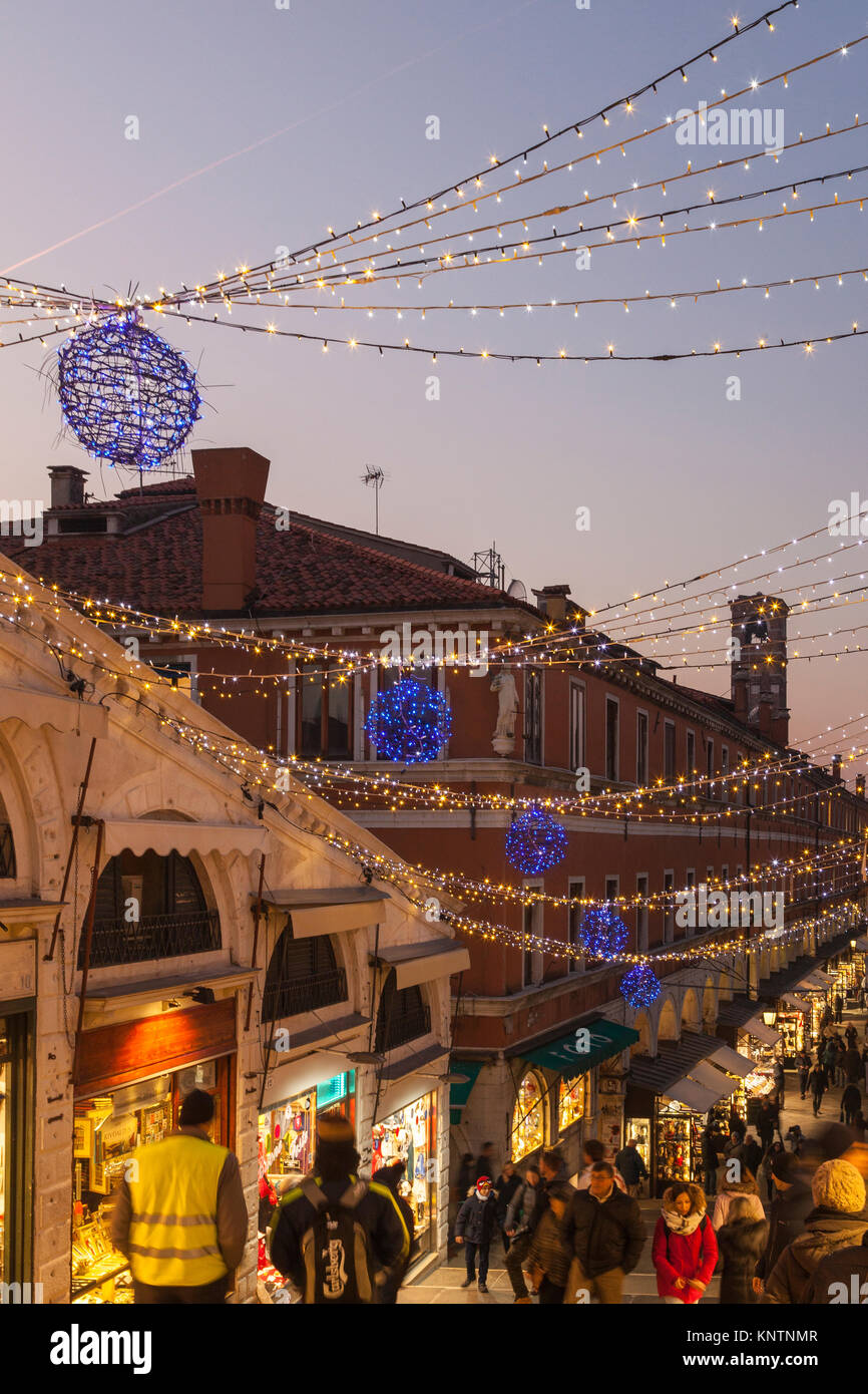 Le luci di Natale Decorare il Ponte di Rialto , San Polo, Venezia, Iatly al tramonto con luminose negozi e folle di persone Foto Stock