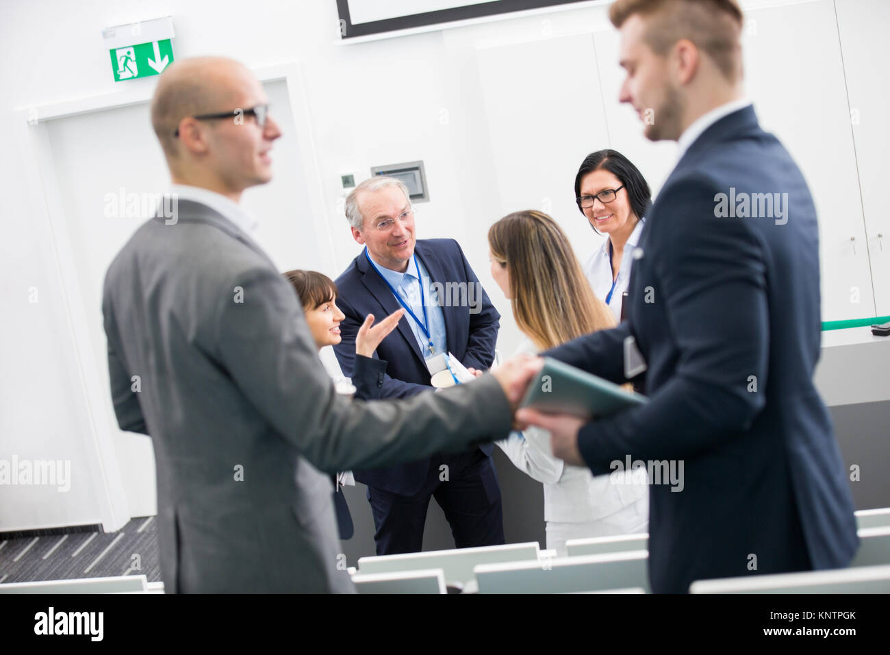 Maschio e femmina di uomini di affari che stringono le mani in aula magna Foto Stock