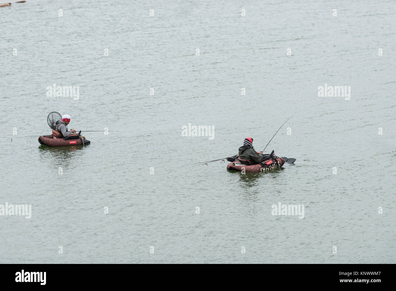 Due pescatori nel ventre imbarcazioni nelle acque del serbatoio di Proserpina, Badajoz, Estremadura, Spagna un giorno di tempesta. Foto Stock