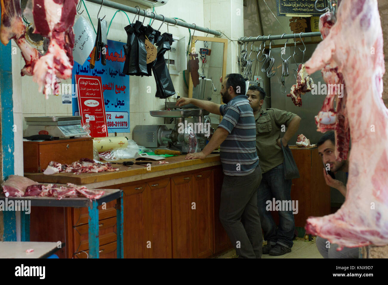 Macellerie pesare e appendere la loro carne nel mercato di Betlemme, West Bank. Foto Stock