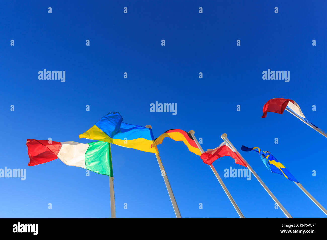 Bandiere europee dell'Italia, Ucraina, Germania, Polonia, Svezia e Francia battenti bandiera su pali contro il cielo blu chiaro Foto Stock