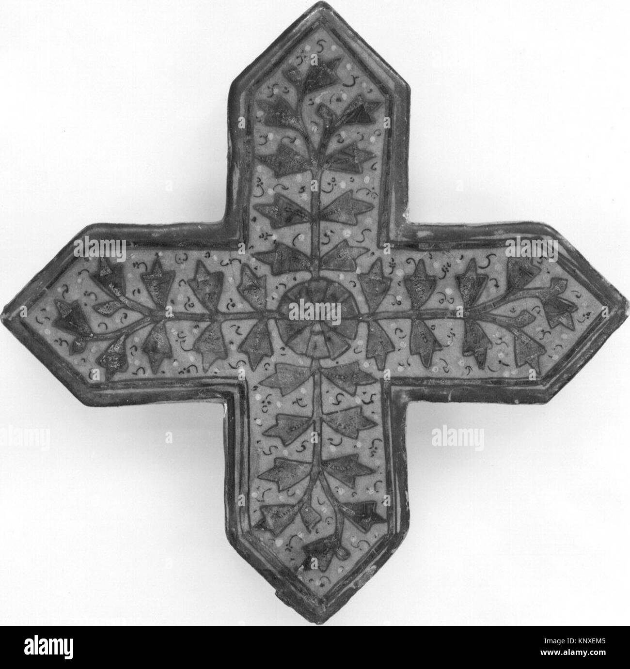 Questo oggetto è una piastrella a forma di croce, che rappresenta lo storico design decorativo e l'artigianato in ceramica. Foto Stock
