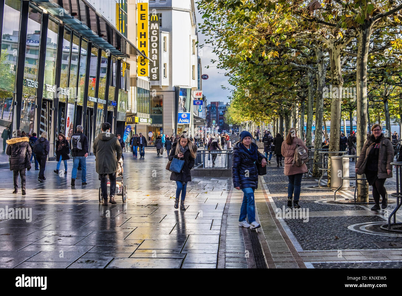Commerciale di Zeil promenade, Francoforte, Germania.Shppers camminando lungo lastricata strada pedonale piena di negozi,pavimentazione decorativa,alberi sfoltiti. Foto Stock
