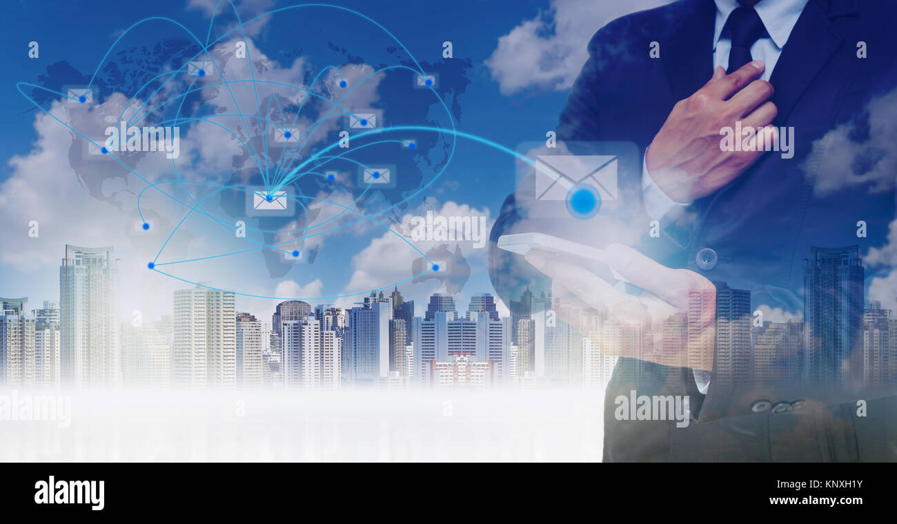 La doppia esposizione di imprenditore utilizzando il tablet per inviare il messaggio di posta elettronica sulla mappa del mondo con la linea di rete oltre il cityscape sfondo, concetto aziendale,E Foto Stock