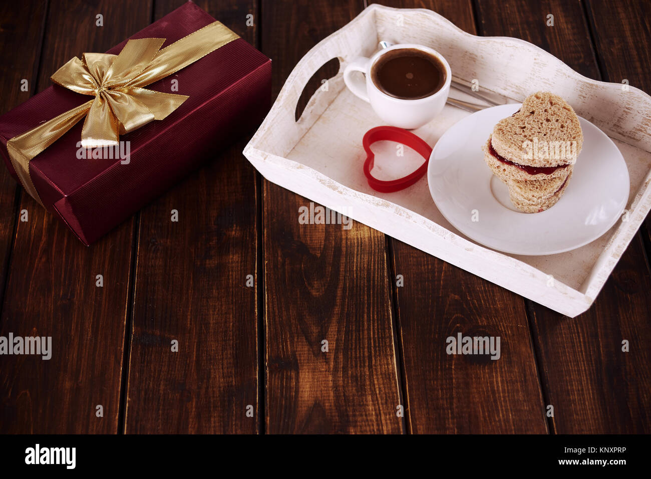 La prima colazione e la confezione regalo rossa per il giorno di San Valentino sul legno scuro tavolo. Copia dello spazio. Foto Stock